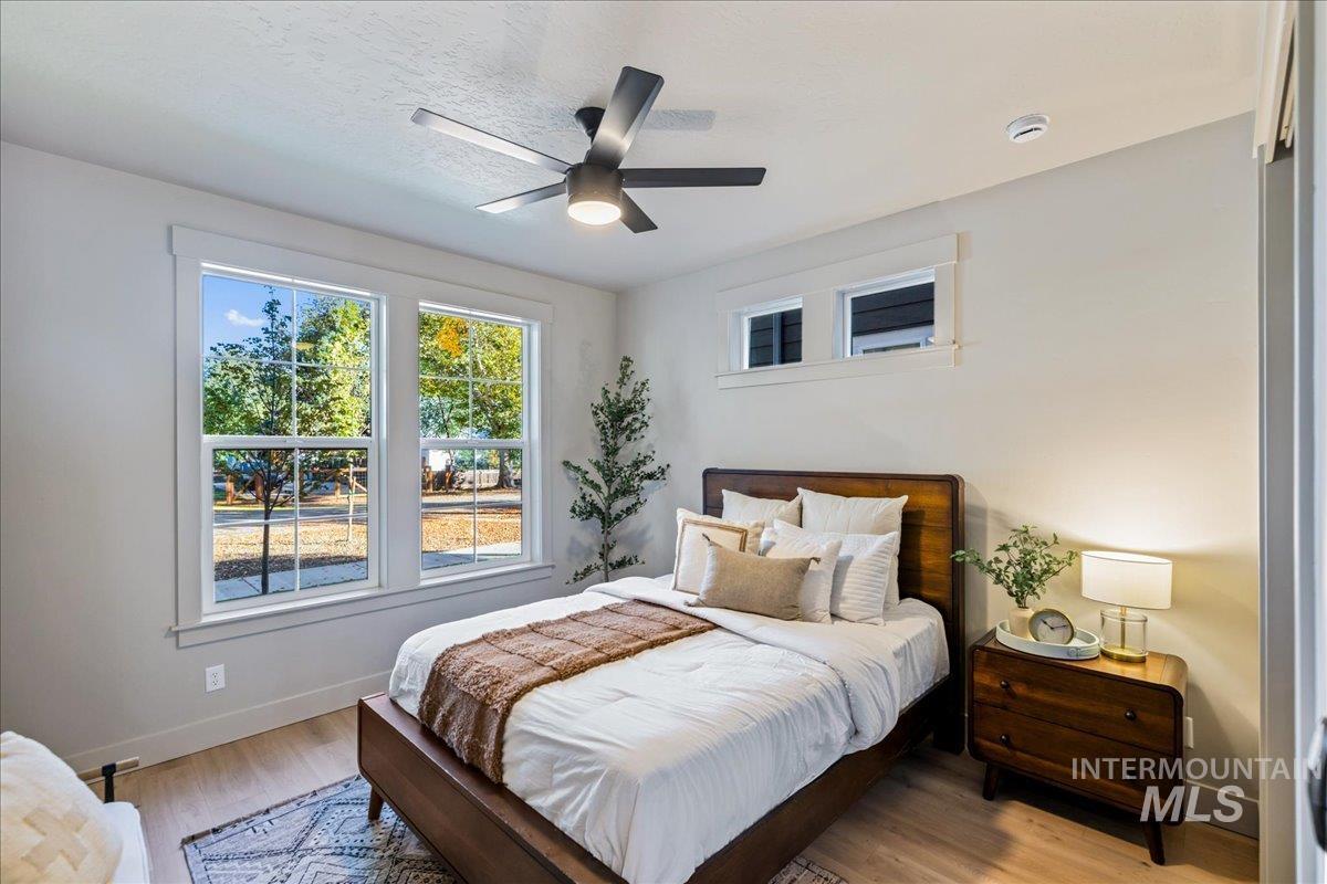 Bedroom featuring wood finished floors, a ceiling fan, and a textured ceiling