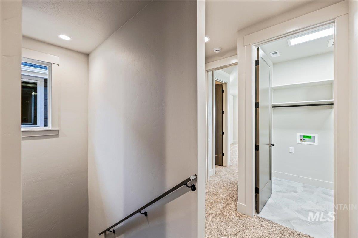 Corridor with recessed lighting and light colored carpet