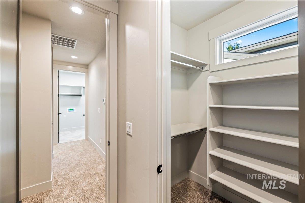 Walk in closet featuring dark colored carpet
