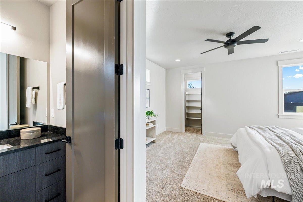 Bedroom featuring light colored carpet, a ceiling fan, and recessed lighting