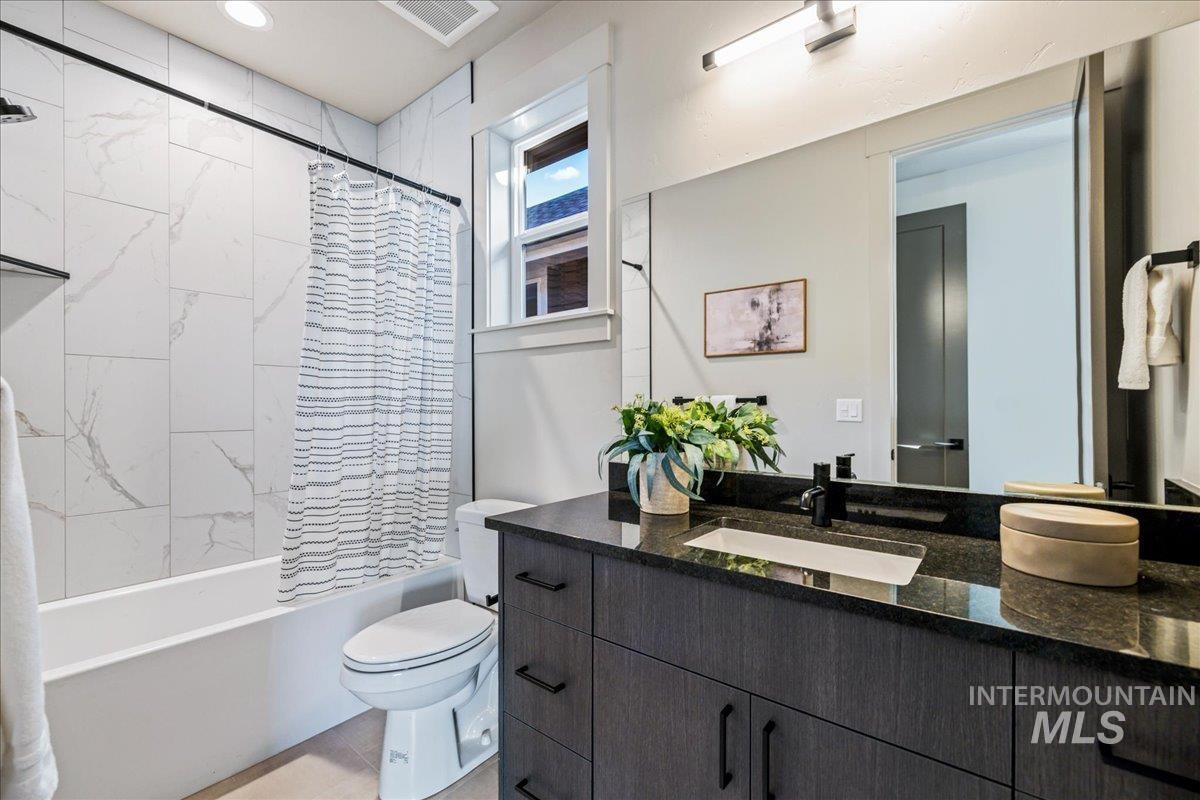 Bathroom featuring shower / bath combo with shower curtain and vanity