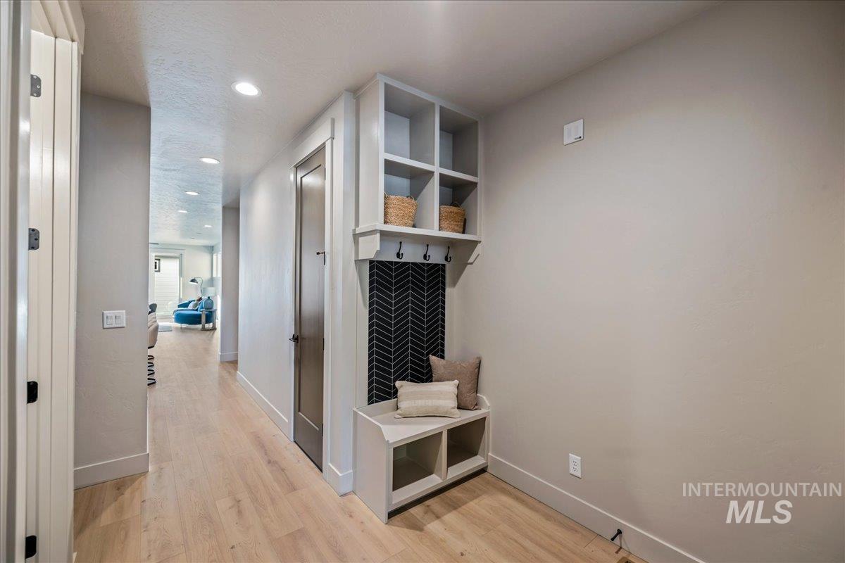 Mudroom with light wood finished floors and recessed lighting