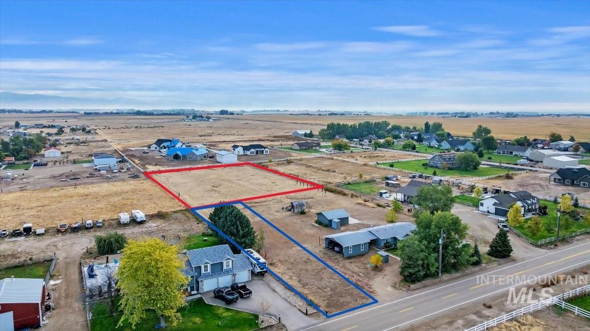 Aerial view of sparsely populated area featuring property parcel outlined