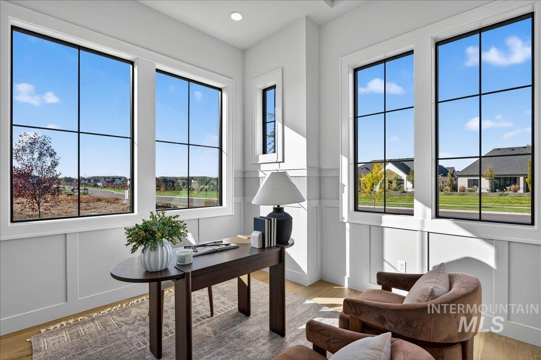 Office with a decorative wall, a wainscoted wall, and light wood finished floors