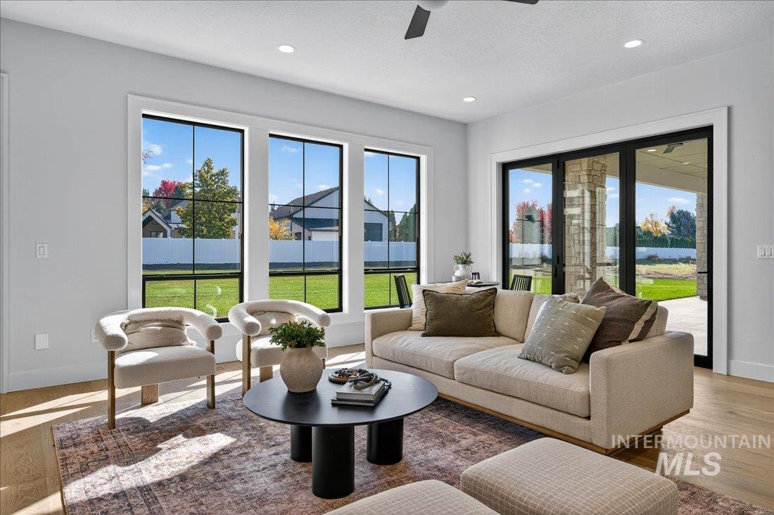 Living area with wood finished floors, plenty of natural light, recessed lighting, a ceiling fan, and a textured ceiling