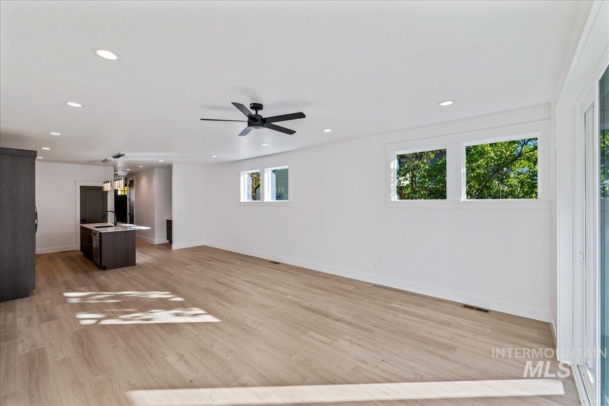Unfurnished living room featuring light wood finished floors, recessed lighting, and ceiling fan