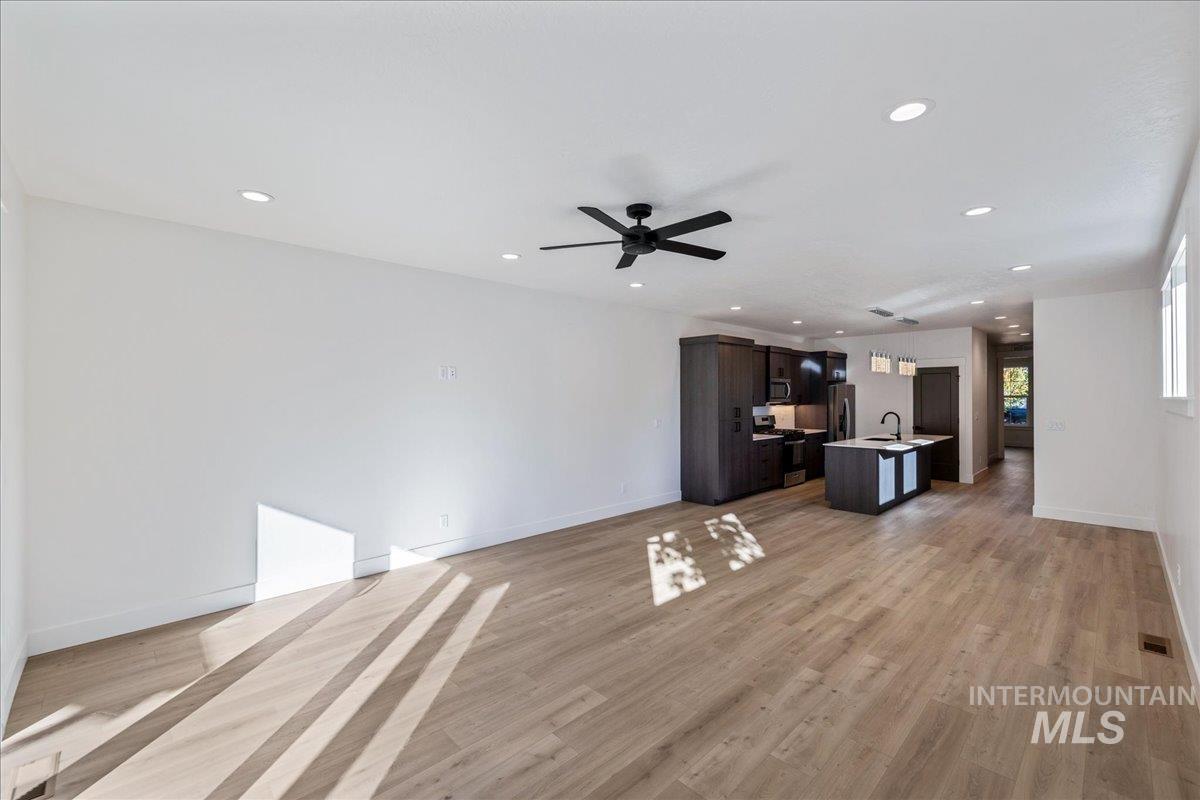 Unfurnished living room featuring light wood-style flooring, recessed lighting, and a ceiling fan