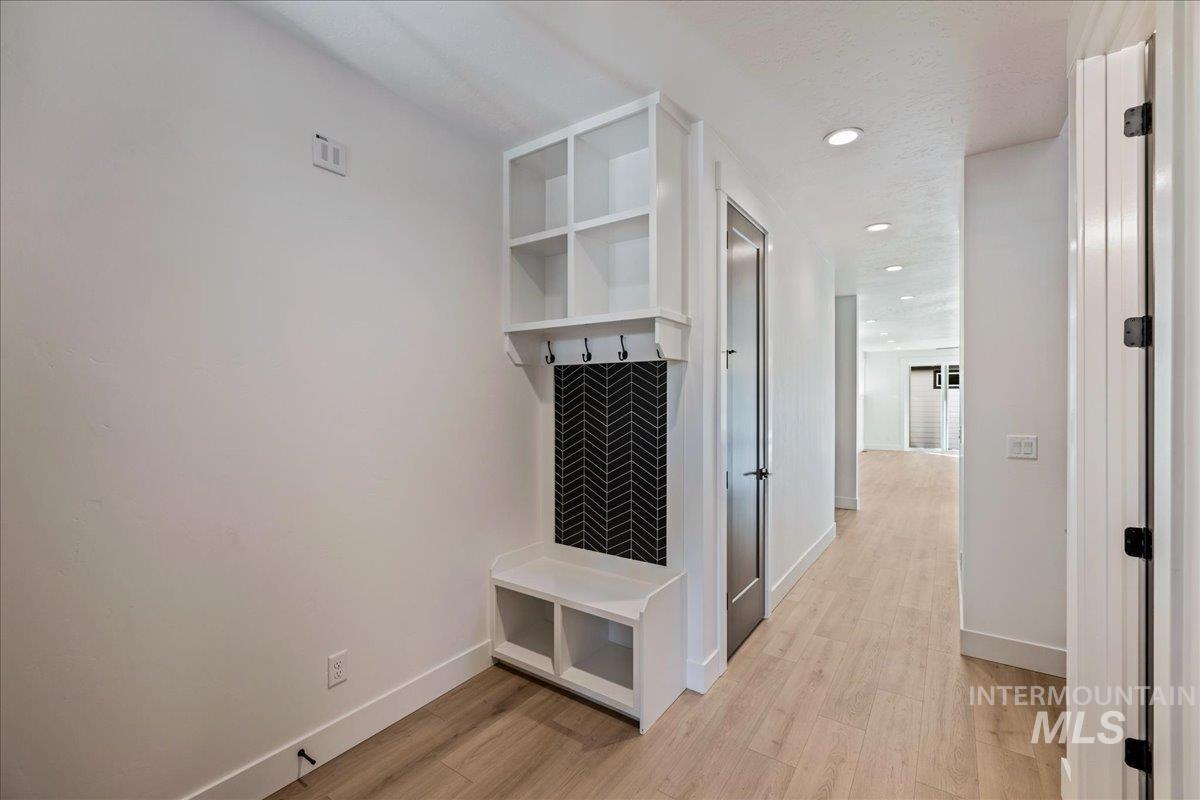 Mudroom with light wood finished floors and recessed lighting