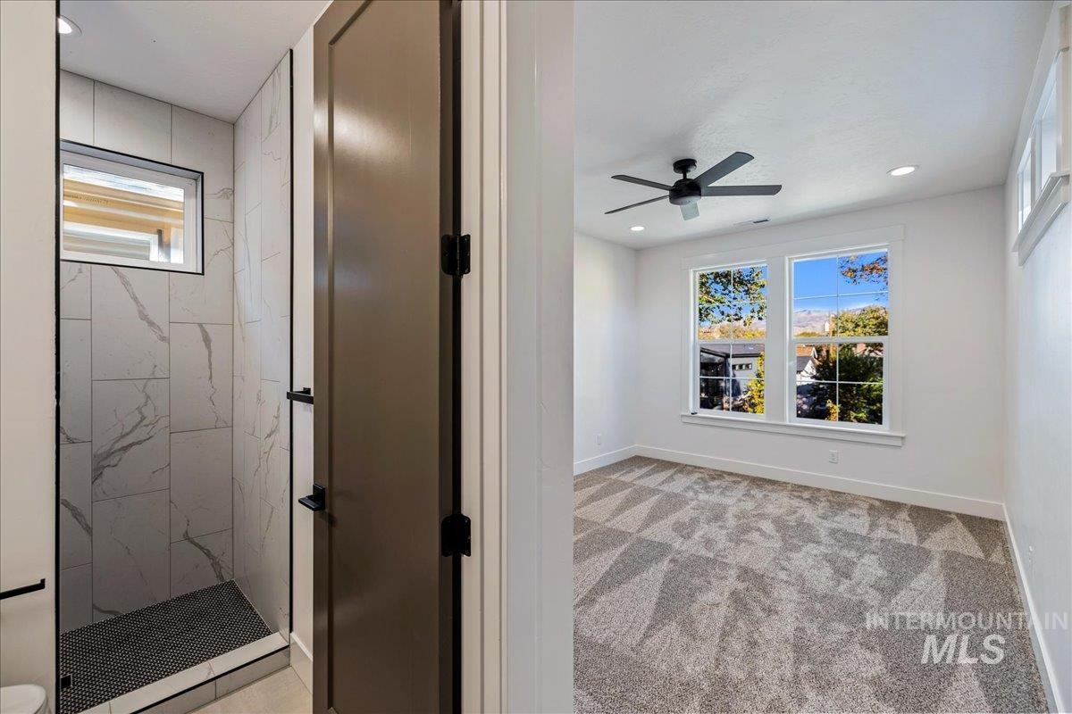 Empty room featuring healthy amount of natural light, recessed lighting, light colored carpet, and a ceiling fan