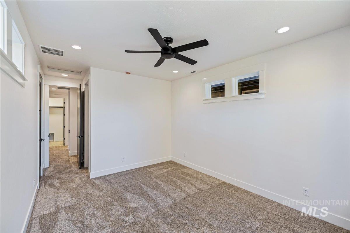 Empty room featuring light carpet, recessed lighting, and a ceiling fan