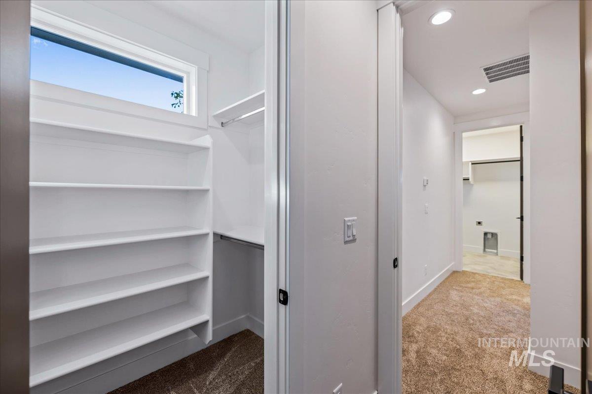 Walk in closet featuring dark carpet