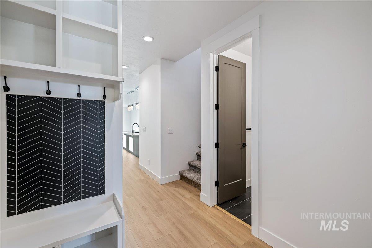 Hall with light wood-style flooring, recessed lighting, and stairway