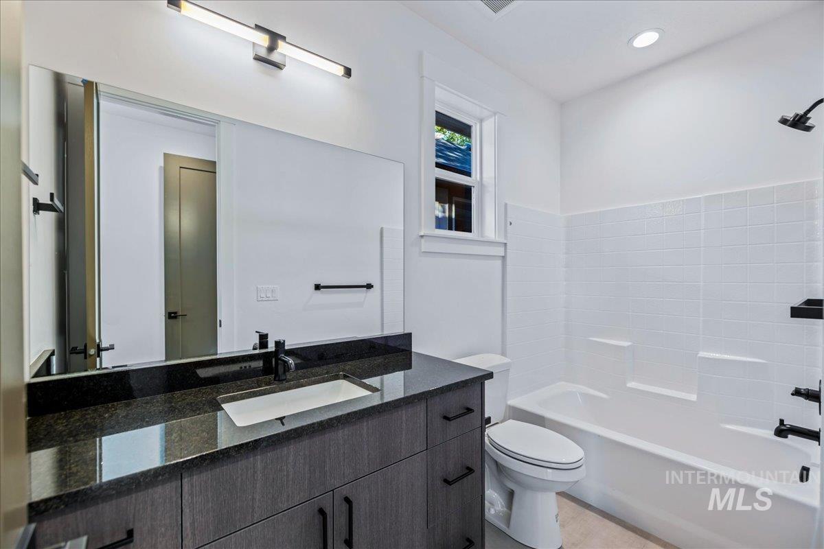 Bathroom featuring vanity, washtub / shower combination, and recessed lighting