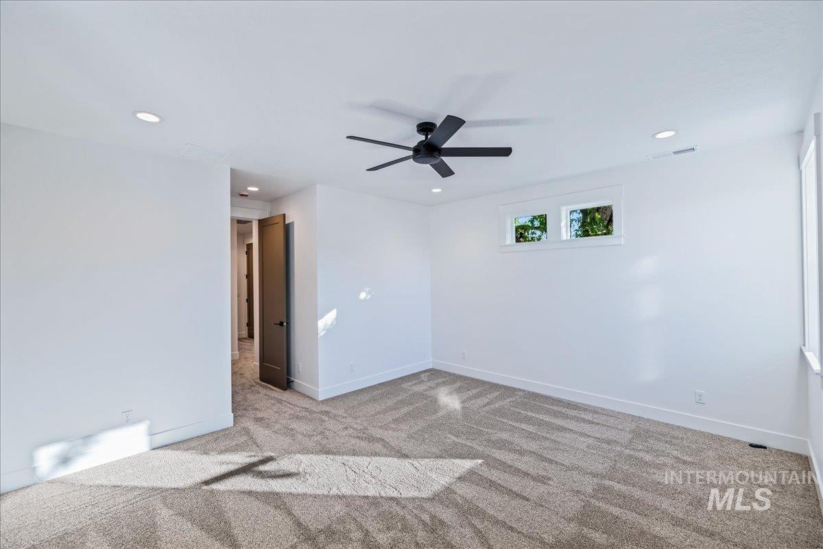 Empty room featuring light carpet, recessed lighting, and a ceiling fan