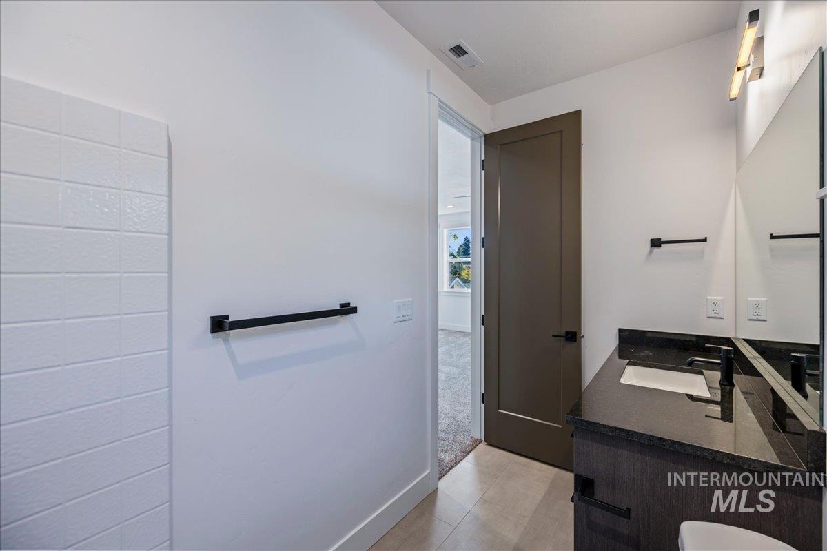 Bathroom featuring vanity and light carpet