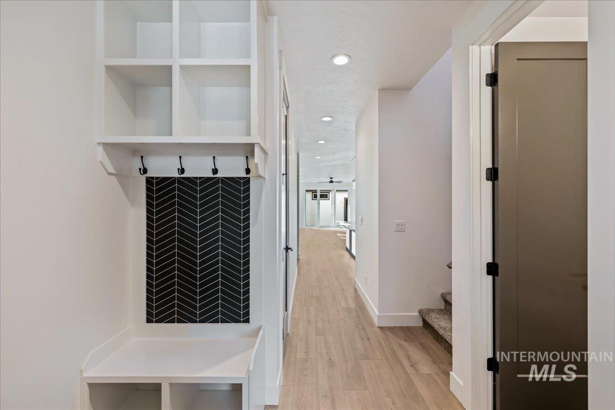 Corridor featuring light wood-style floors, recessed lighting, and stairs
