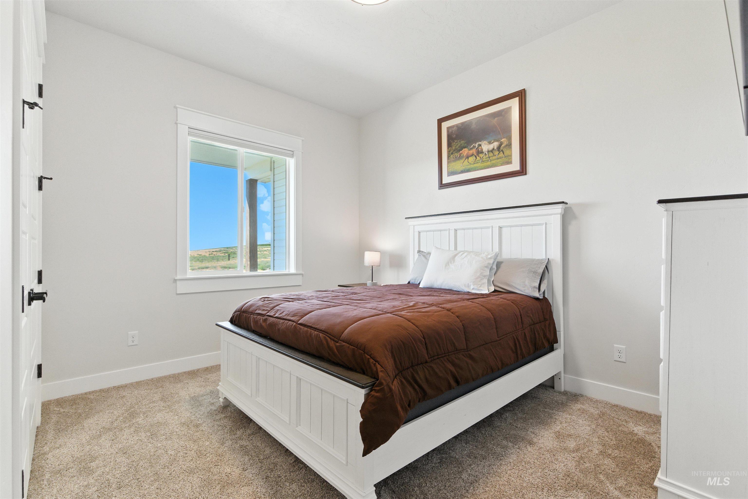 Bedroom featuring baseboards and light colored carpet