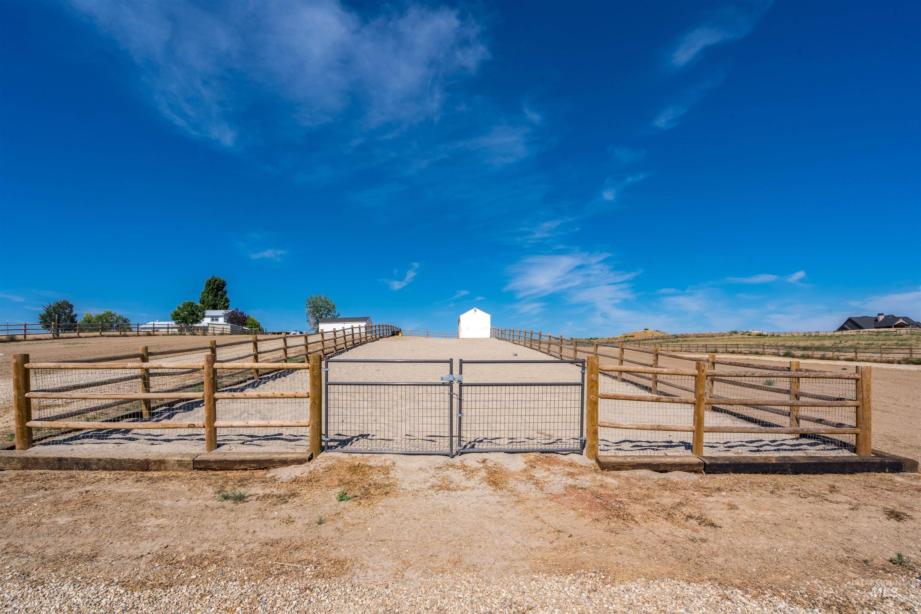 View of yard featuring an outdoor riding arena, a view of countryside, and an outbuilding