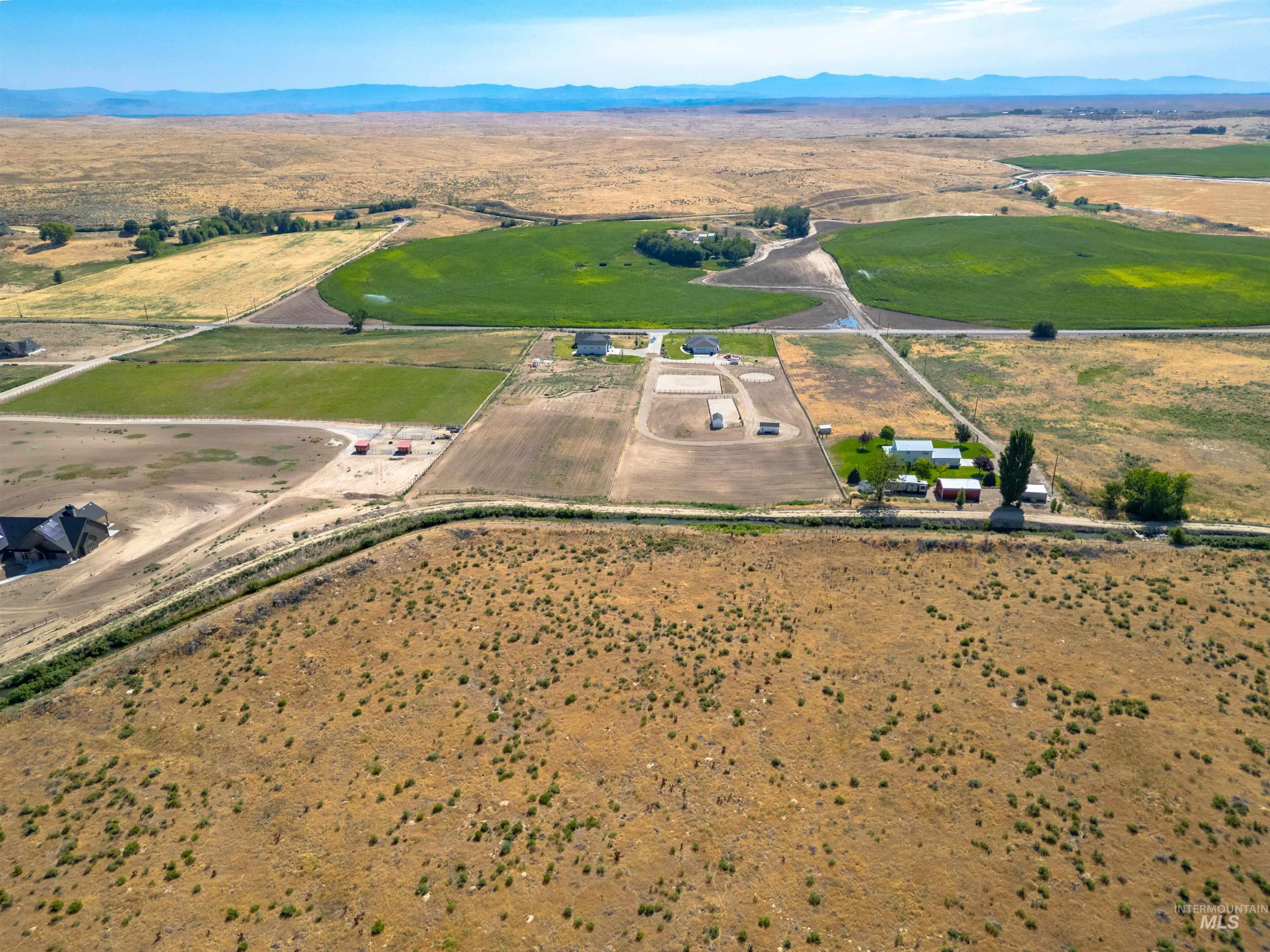 Aerial view of property and surrounding area with rural landscape and a mountainous background
