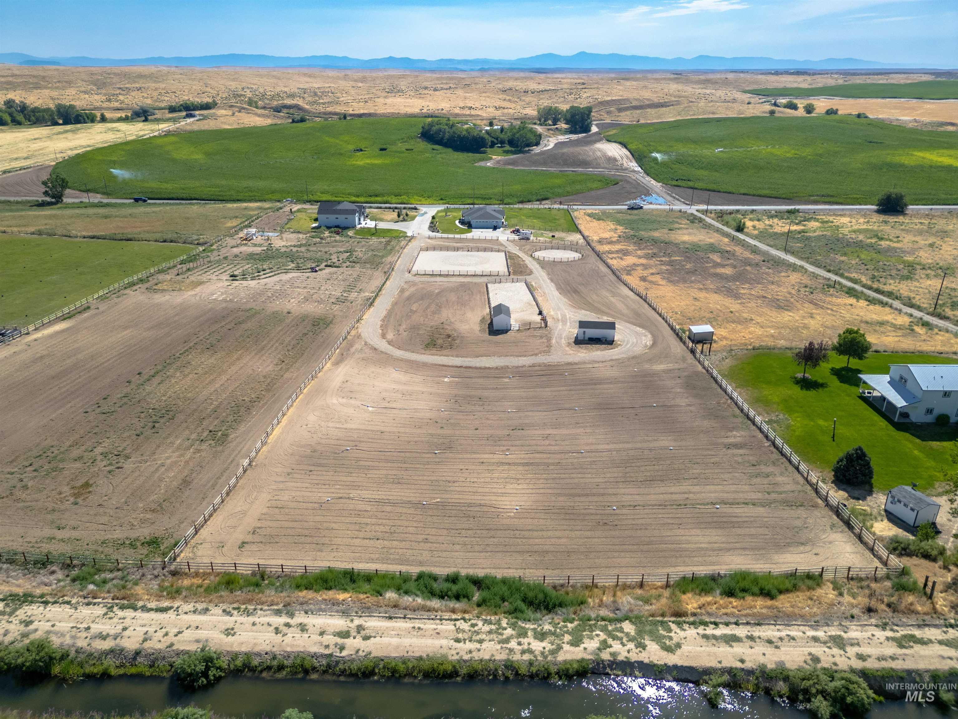 Aerial view of property and surrounding area with rural landscape and a mountainous background