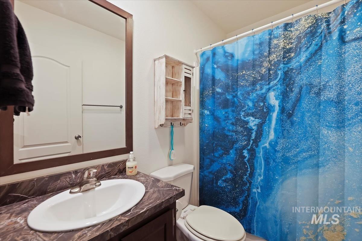 Bathroom with a shower with curtain and vanity