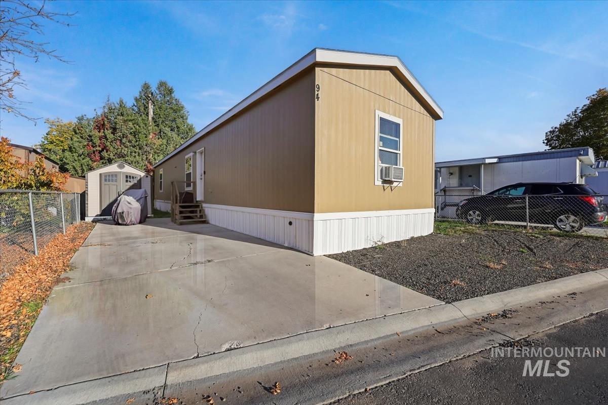 View of side of home featuring a storage shed and entry steps
