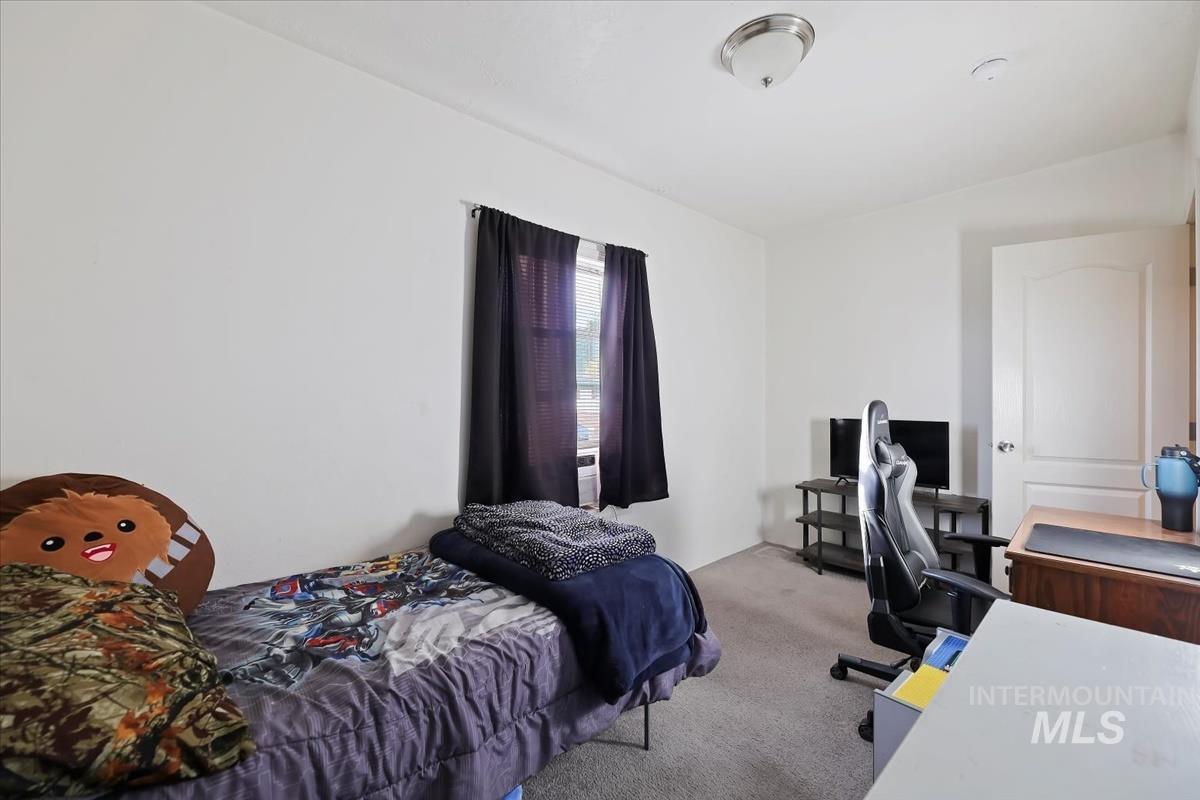 Bedroom featuring an office area and carpet flooring