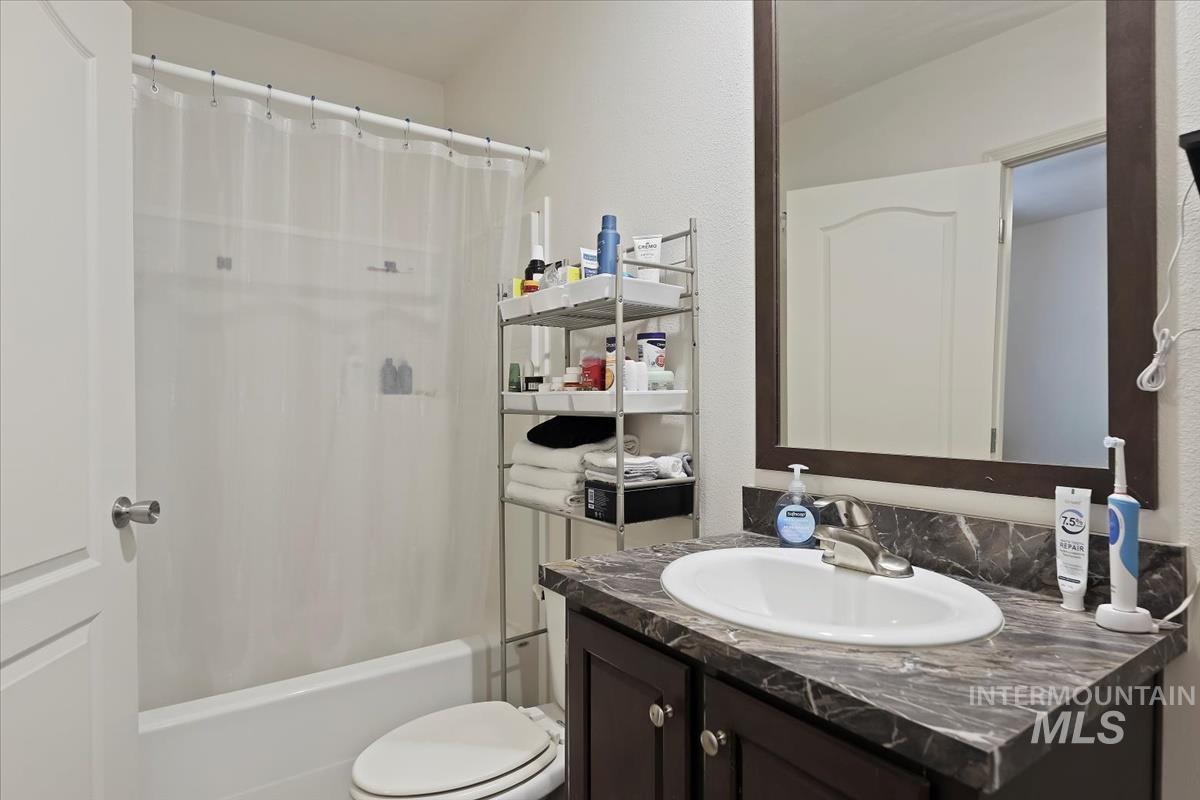 Bathroom featuring vanity and shower / bath combination with curtain