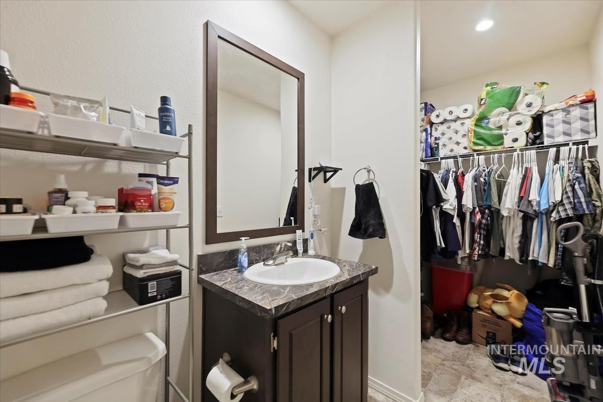 Bathroom with vanity and a walk in closet