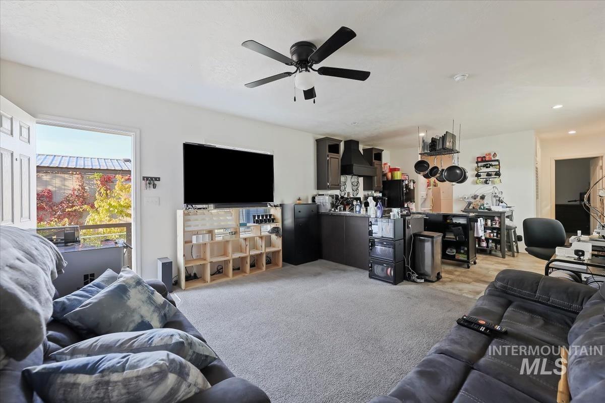 Living area featuring light colored carpet and a ceiling fan