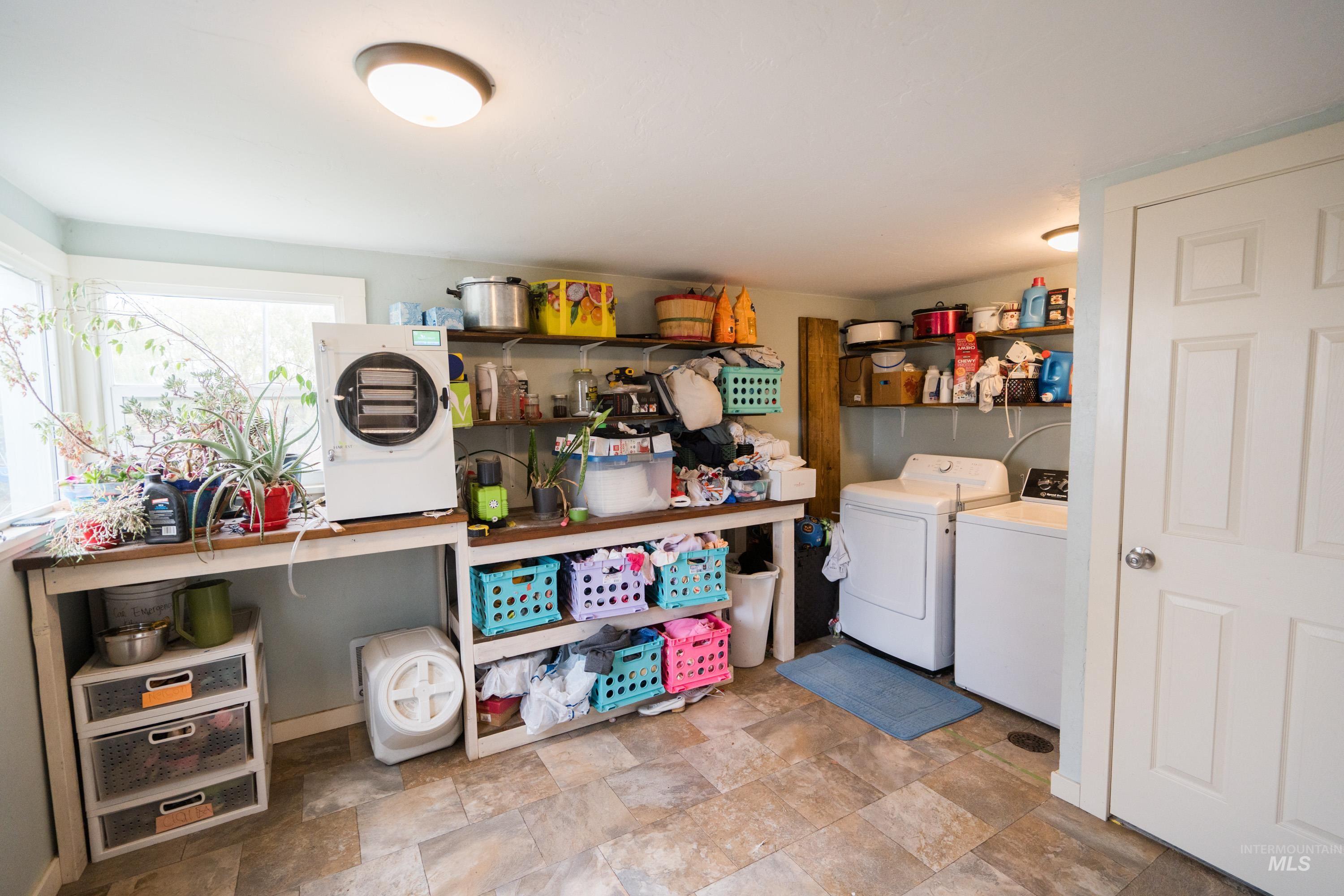 Washroom with stone finish floors and independent washer and dryer