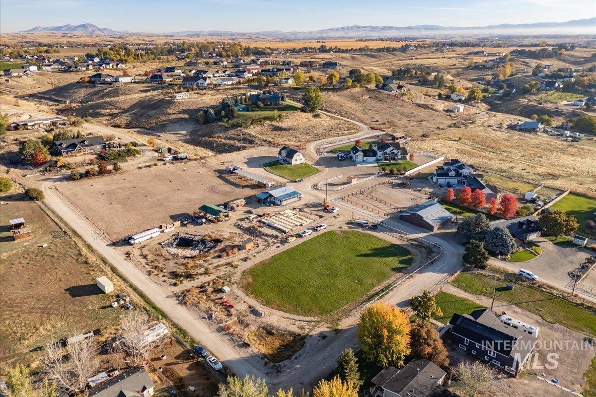 Aerial view of property and surrounding area featuring mountains and rural landscape