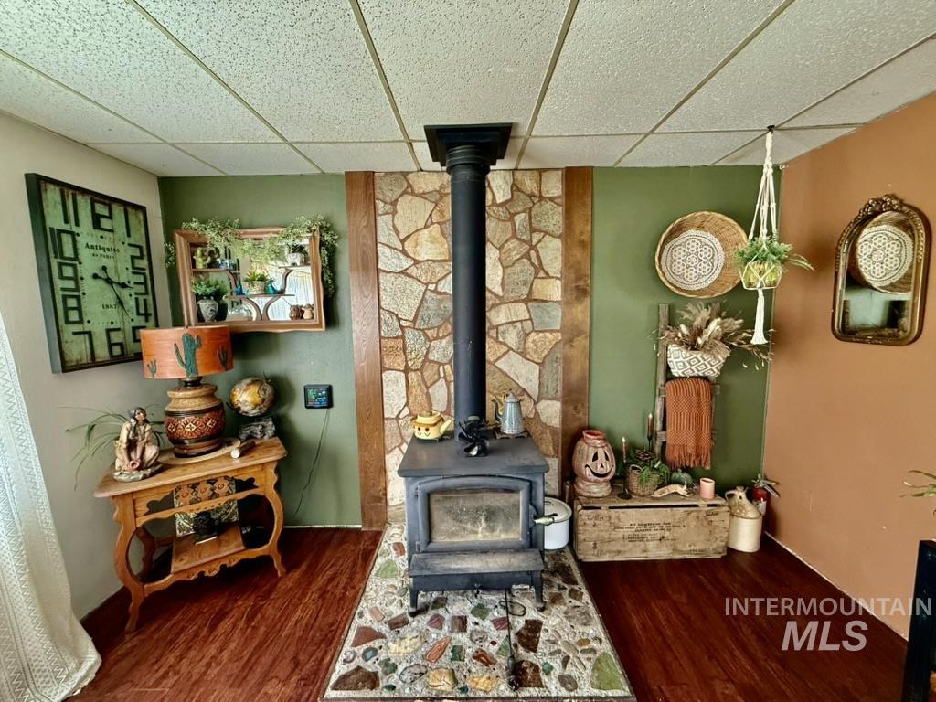 Detailed view of a drop ceiling, a wood stove, and wood finished floors