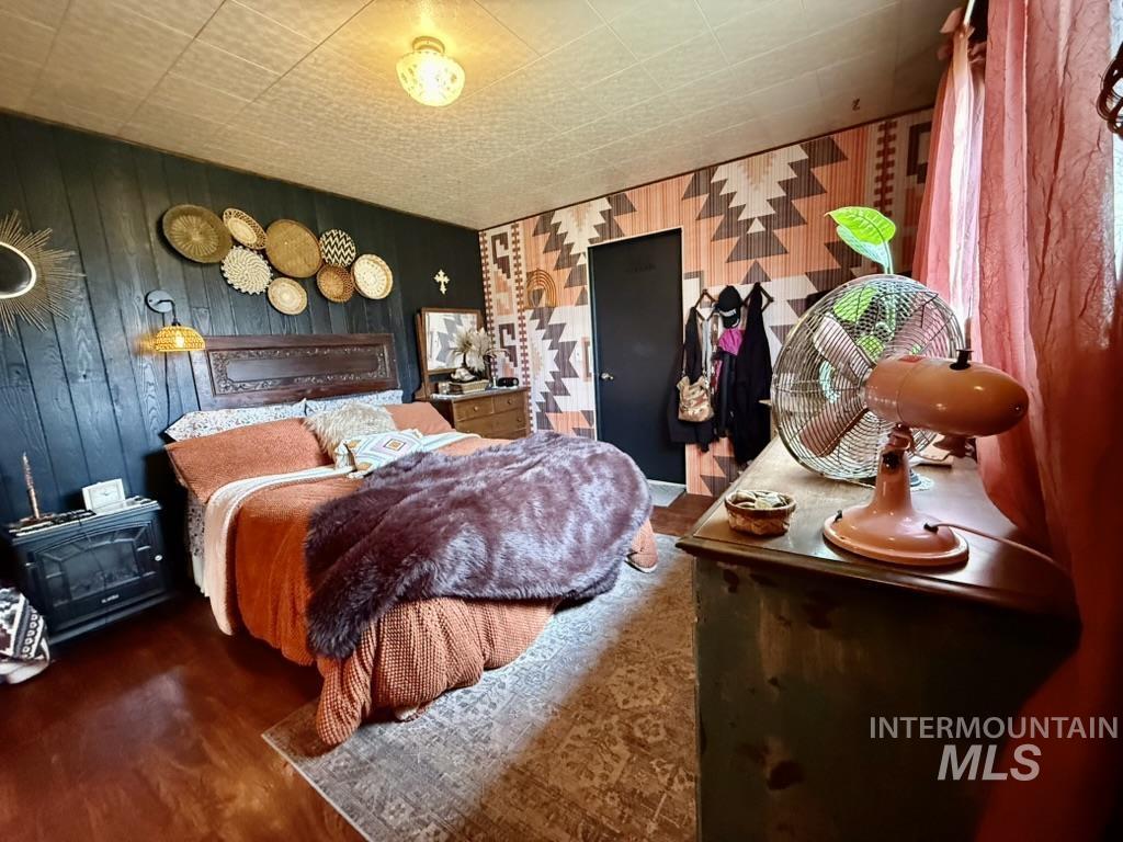Bedroom featuring wood finished floors and wooden walls