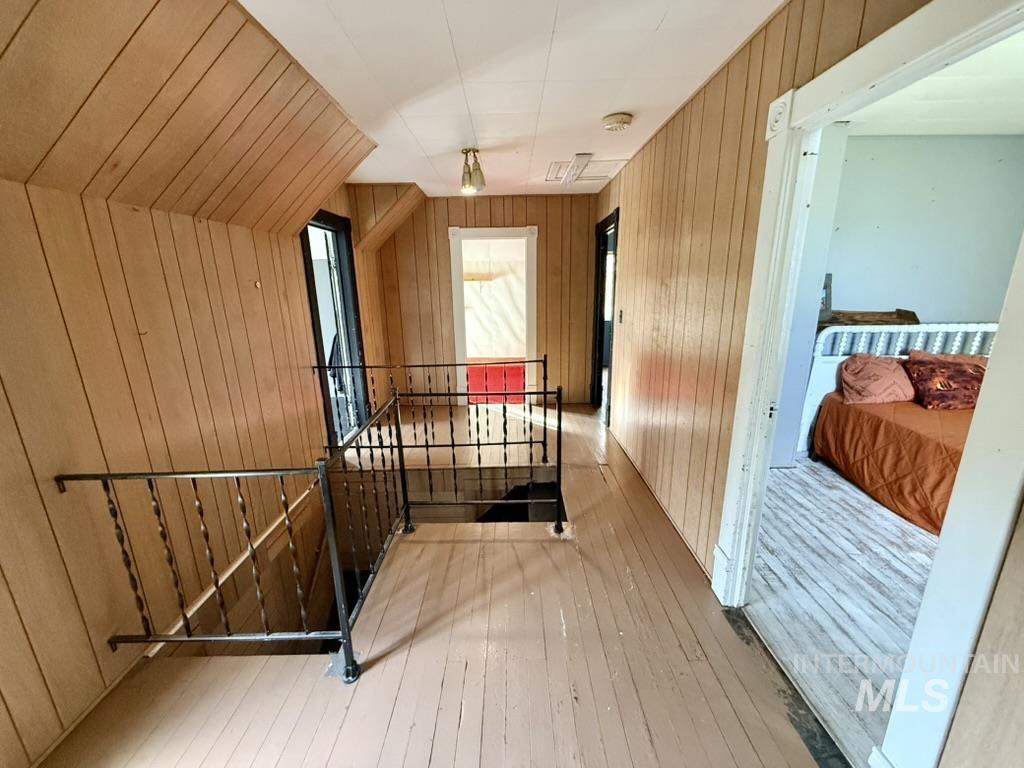 Bonus room with wooden walls and hardwood / wood-style floors