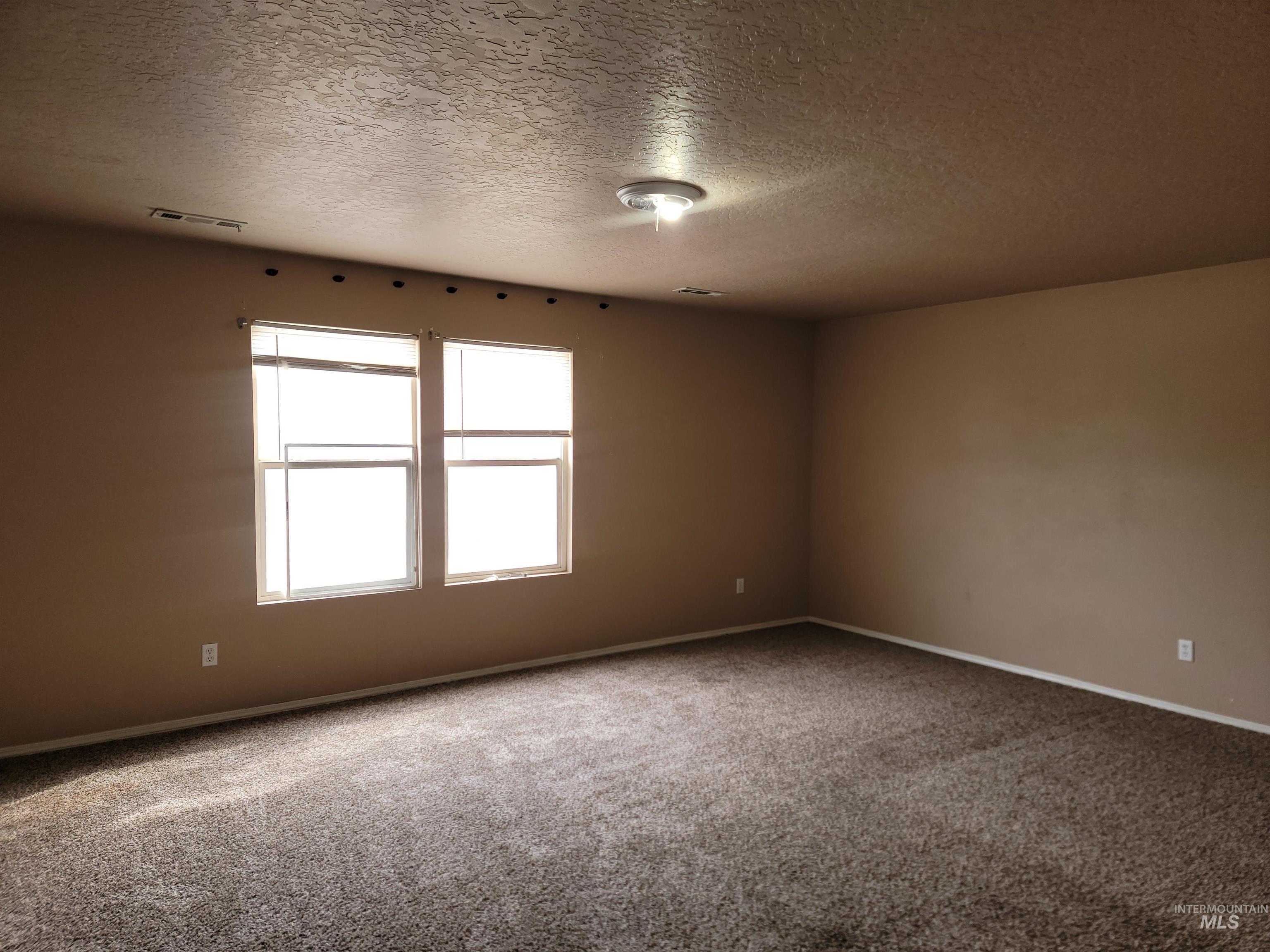 Spare room with a textured ceiling and carpet floors