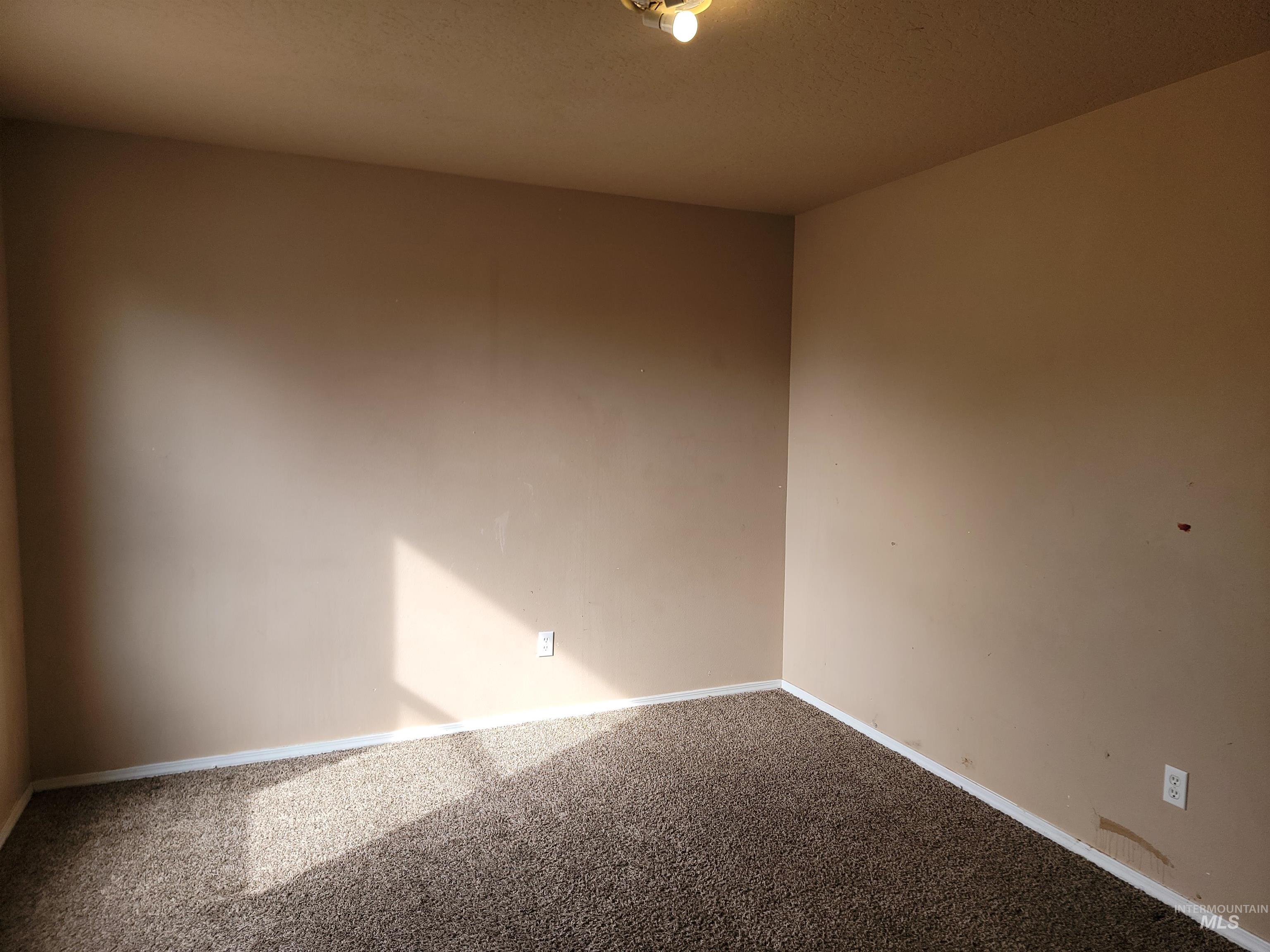 Empty room featuring baseboards and carpet floors