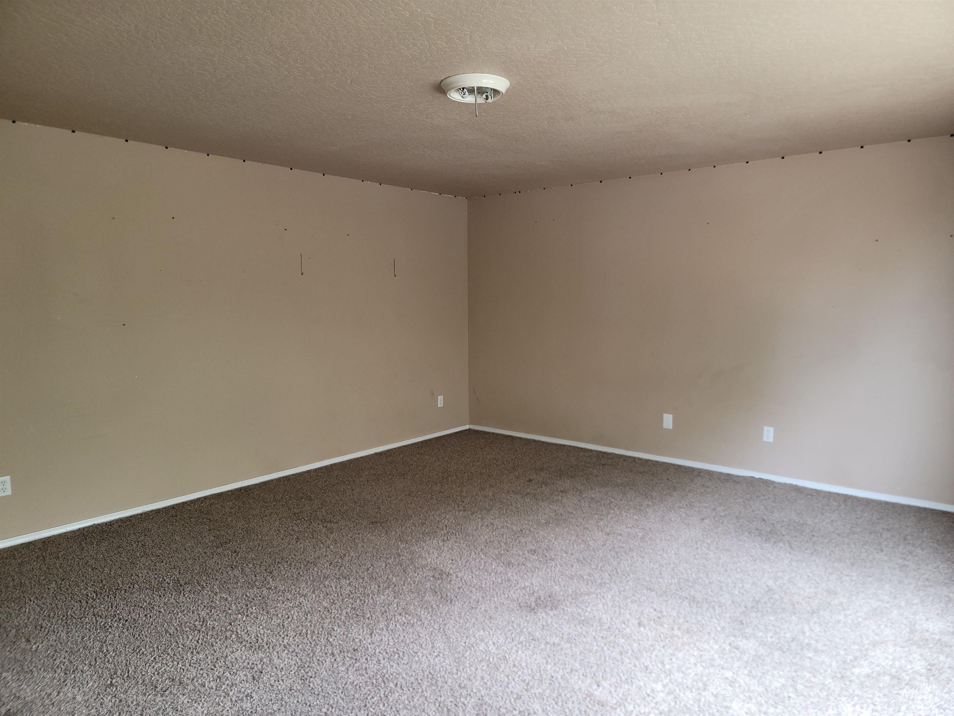 Spare room with a textured ceiling and carpet