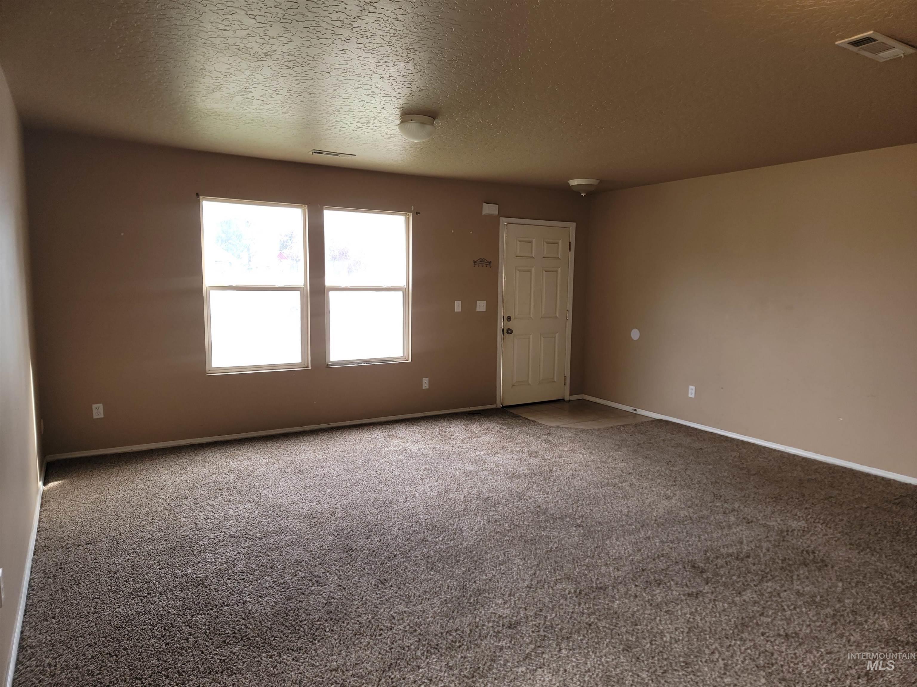Unfurnished room with carpet floors and a textured ceiling