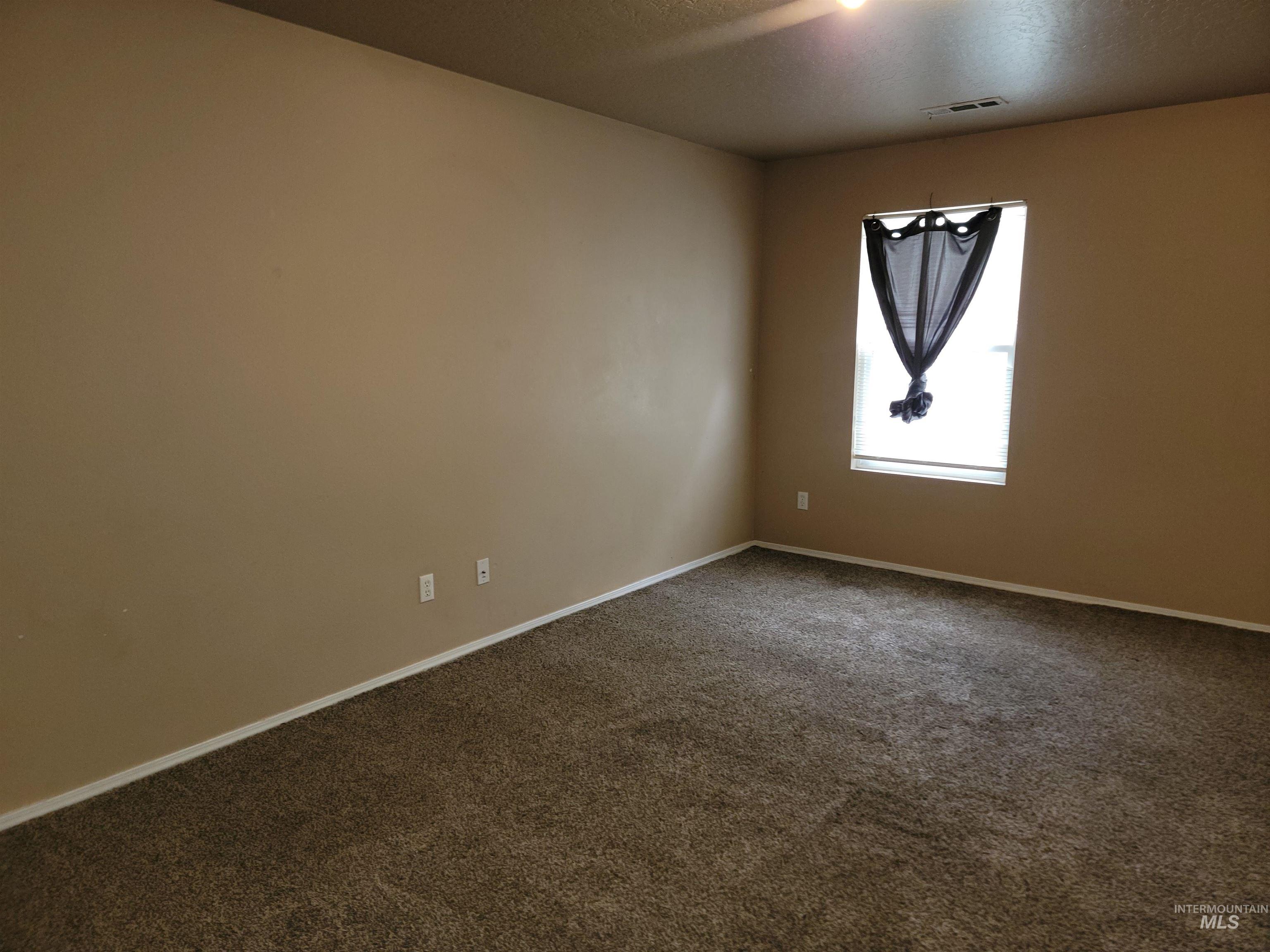 Unfurnished room featuring carpet flooring and a textured ceiling