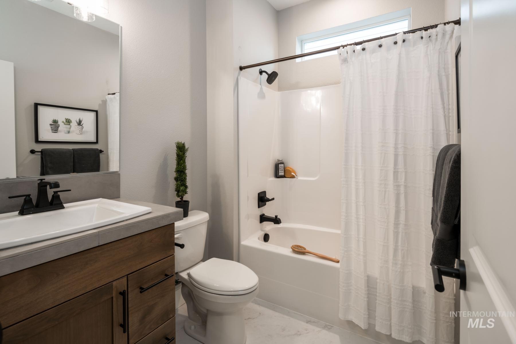 Full bath with shower / bath combo with shower curtain and vanity