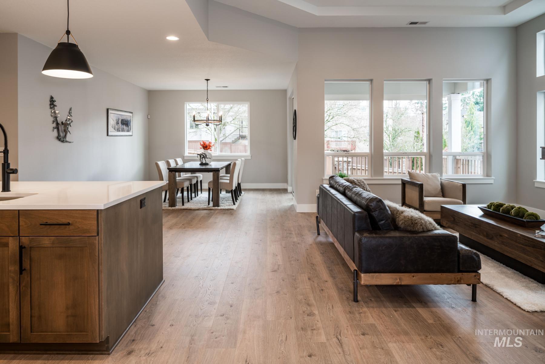 Living area featuring light wood finished floors, a chandelier, and recessed lighting