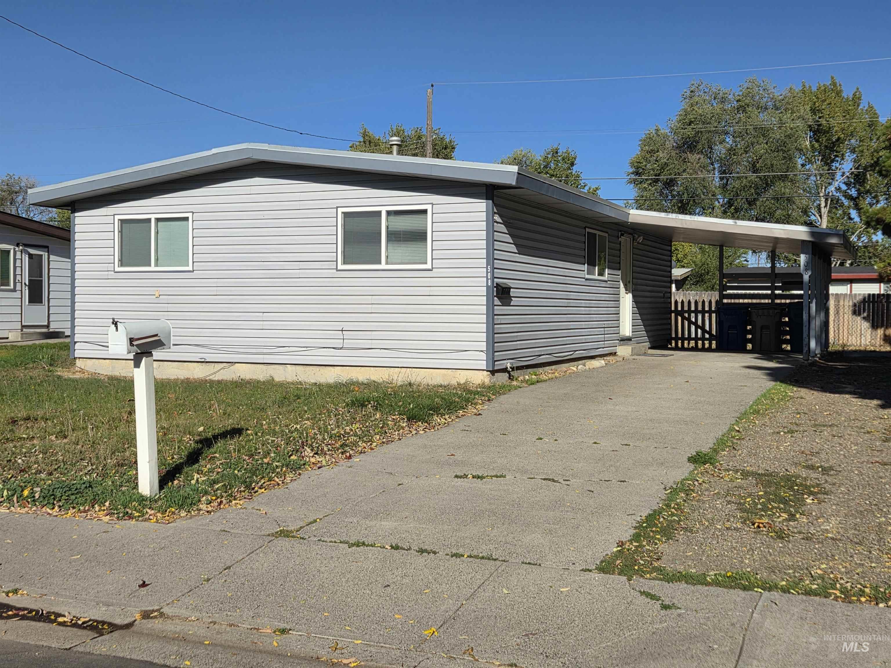 View of side of property featuring driveway and a carport