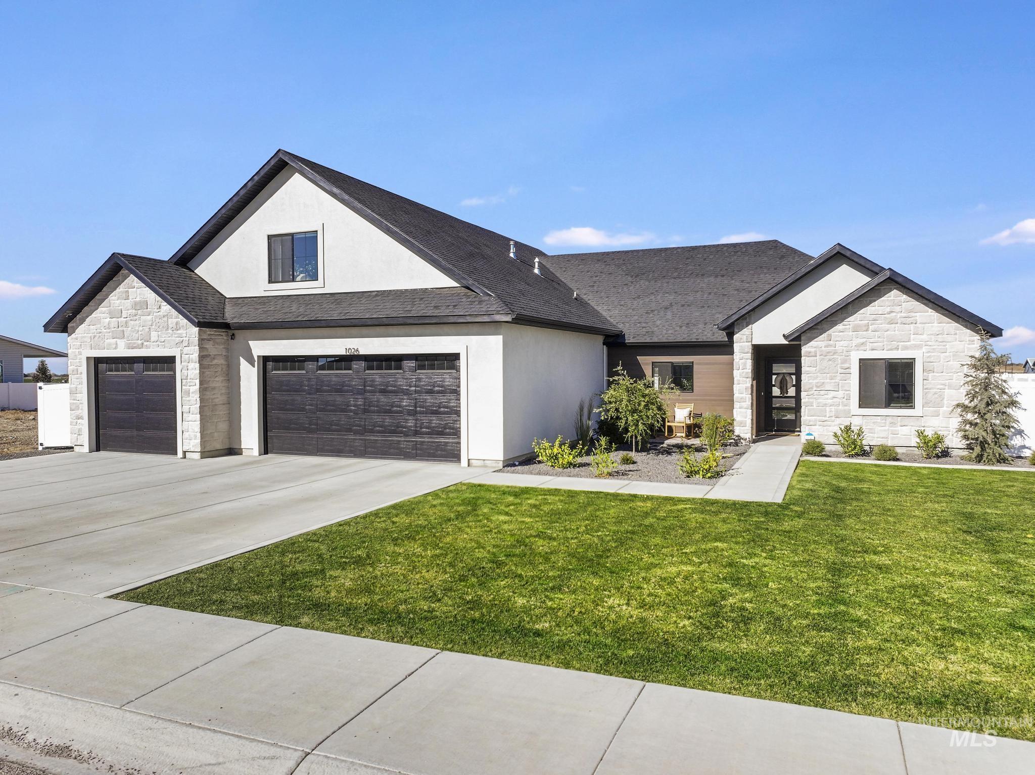 Modern inspired farmhouse with stone siding, concrete driveway, a front lawn, stucco siding, and roof with shingles