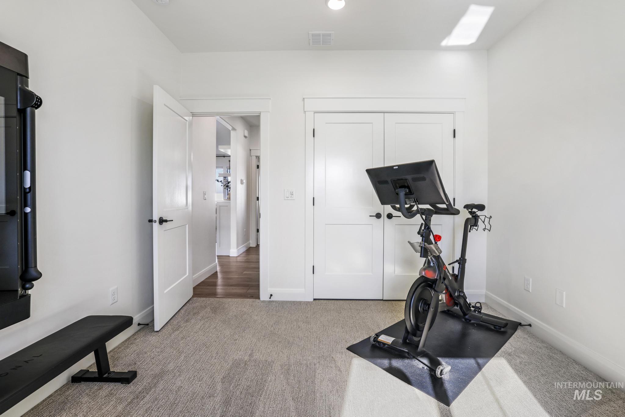 Exercise area featuring light colored carpet and recessed lighting