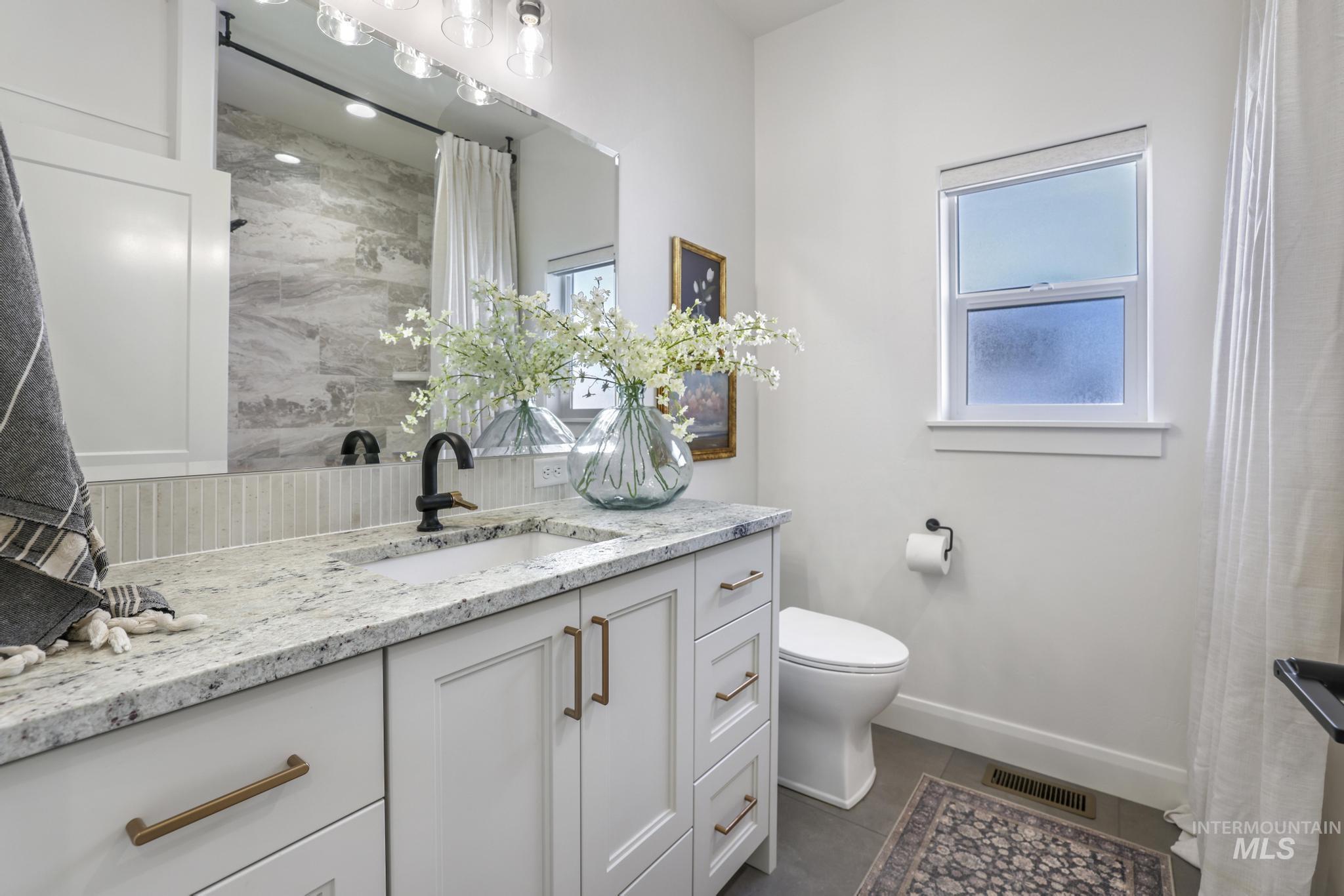 Full bath with vanity, a shower with curtain, and dark tile patterned floors