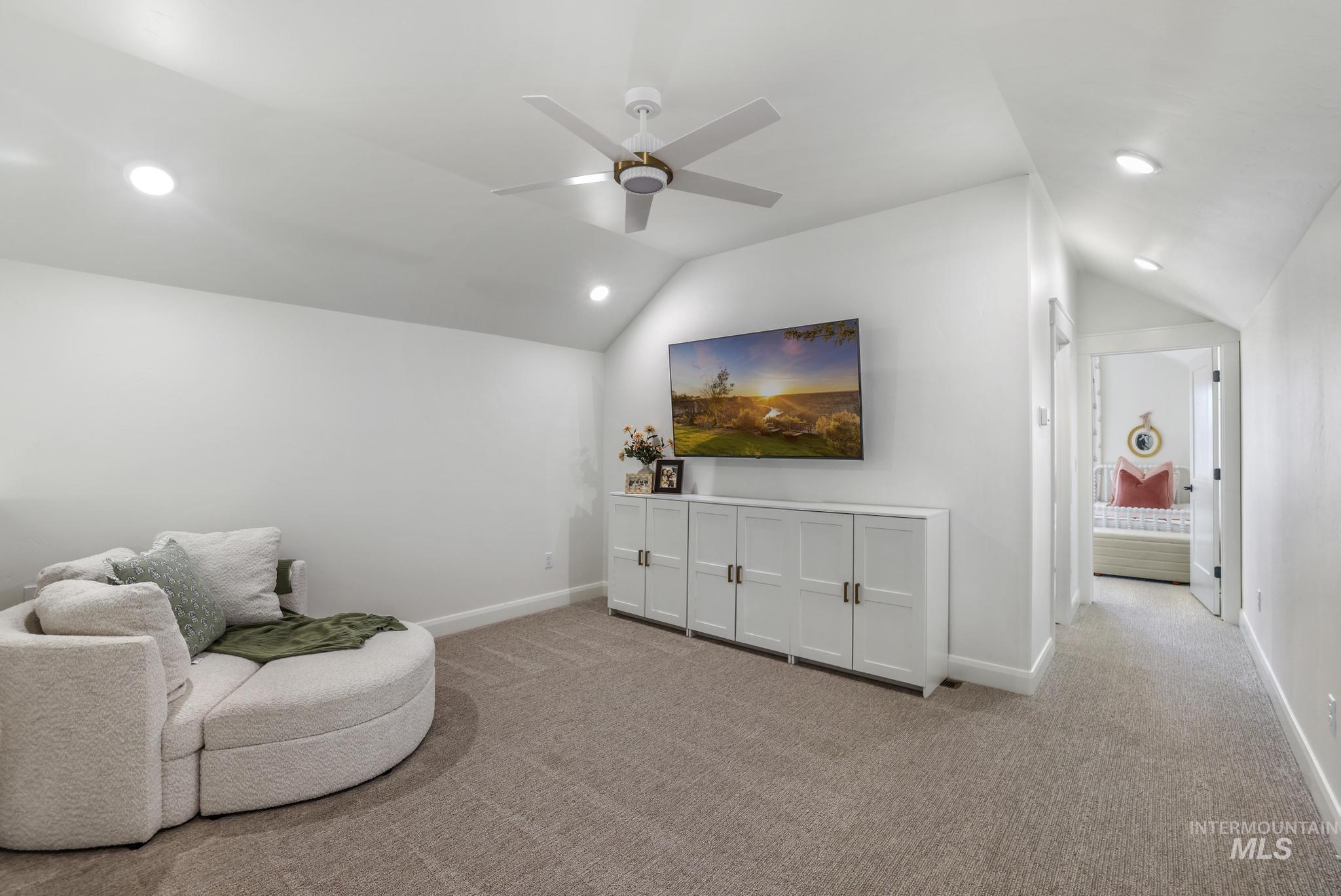 Living area featuring carpet floors, vaulted ceiling, recessed lighting, and ceiling fan