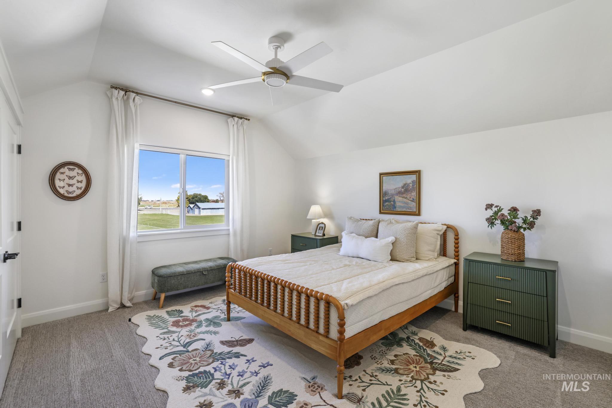 Bedroom featuring vaulted ceiling, carpet flooring, and a ceiling fan