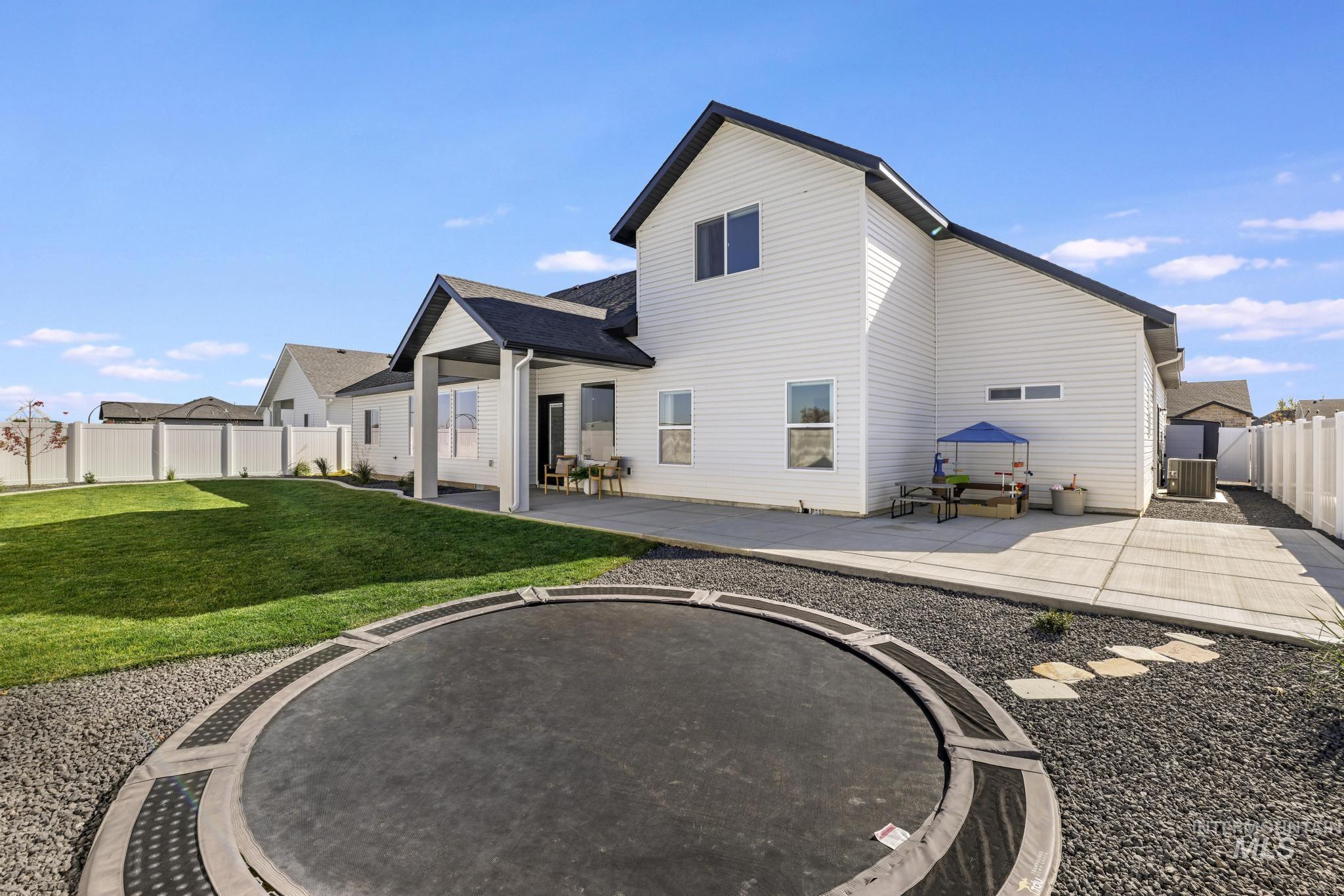Rear view of house featuring a patio and a fenced backyard