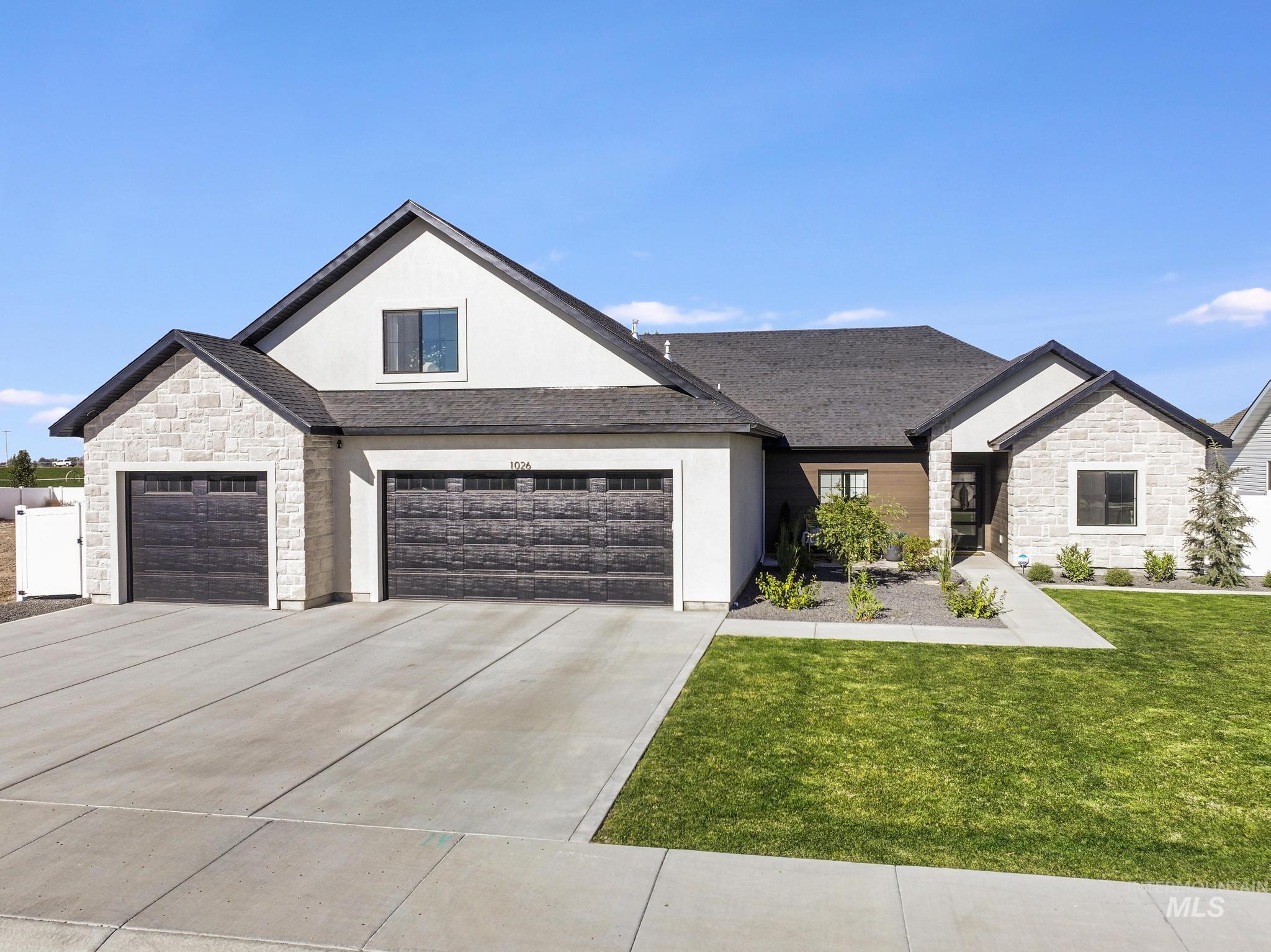 View of front of property with stone siding, driveway, a front yard, stucco siding, and a shingled roof